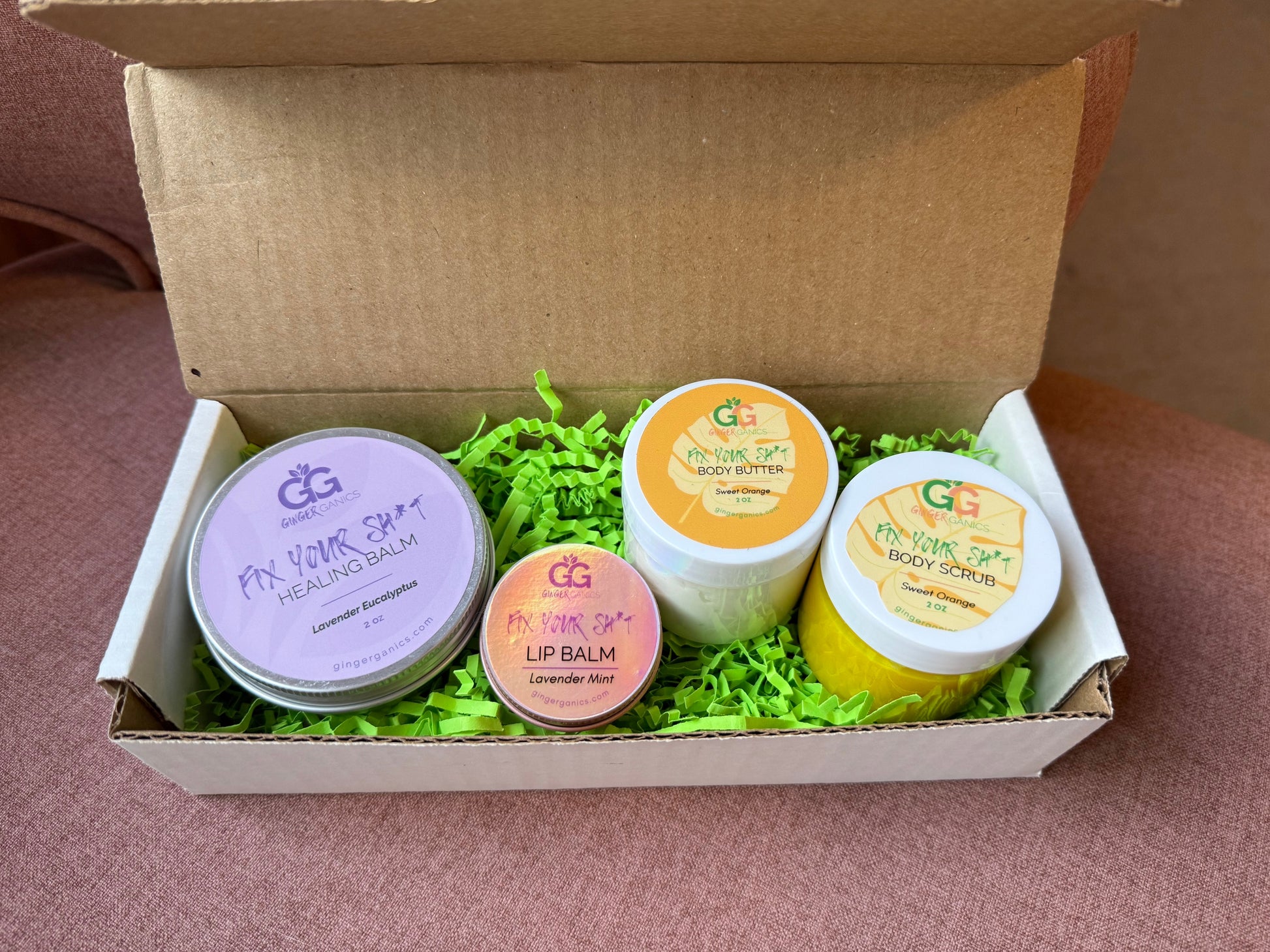 Set of skincare products in a cardboard gift box with green paper filler